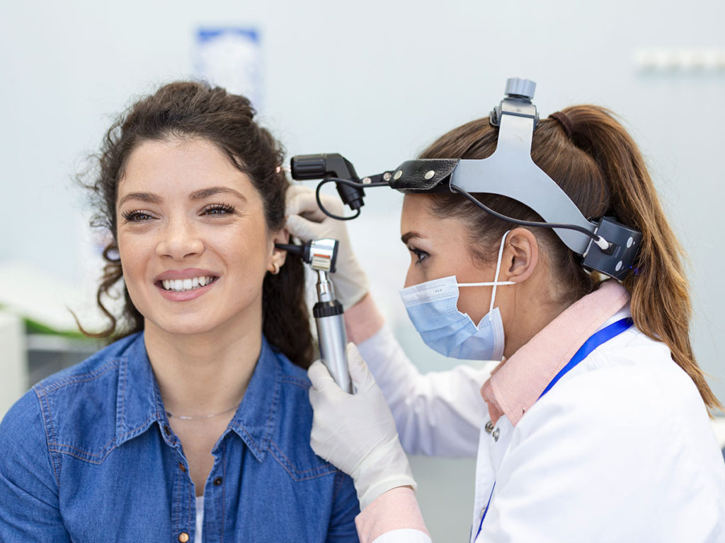 doctora revisando el oído de un paciente